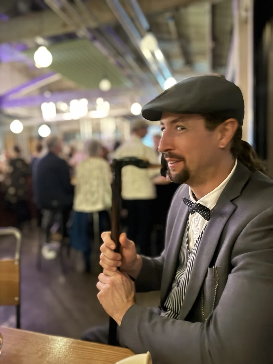 Ryan in a flat cap and suit